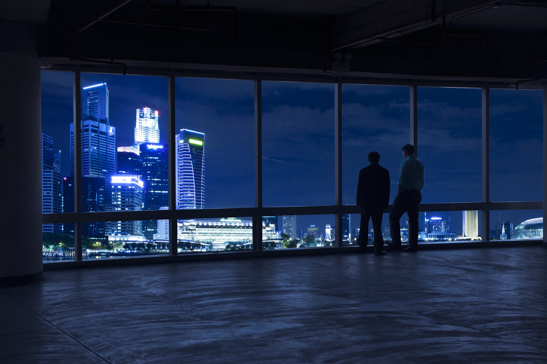 Two businessmen looking out the window at the Singapore city-scape
