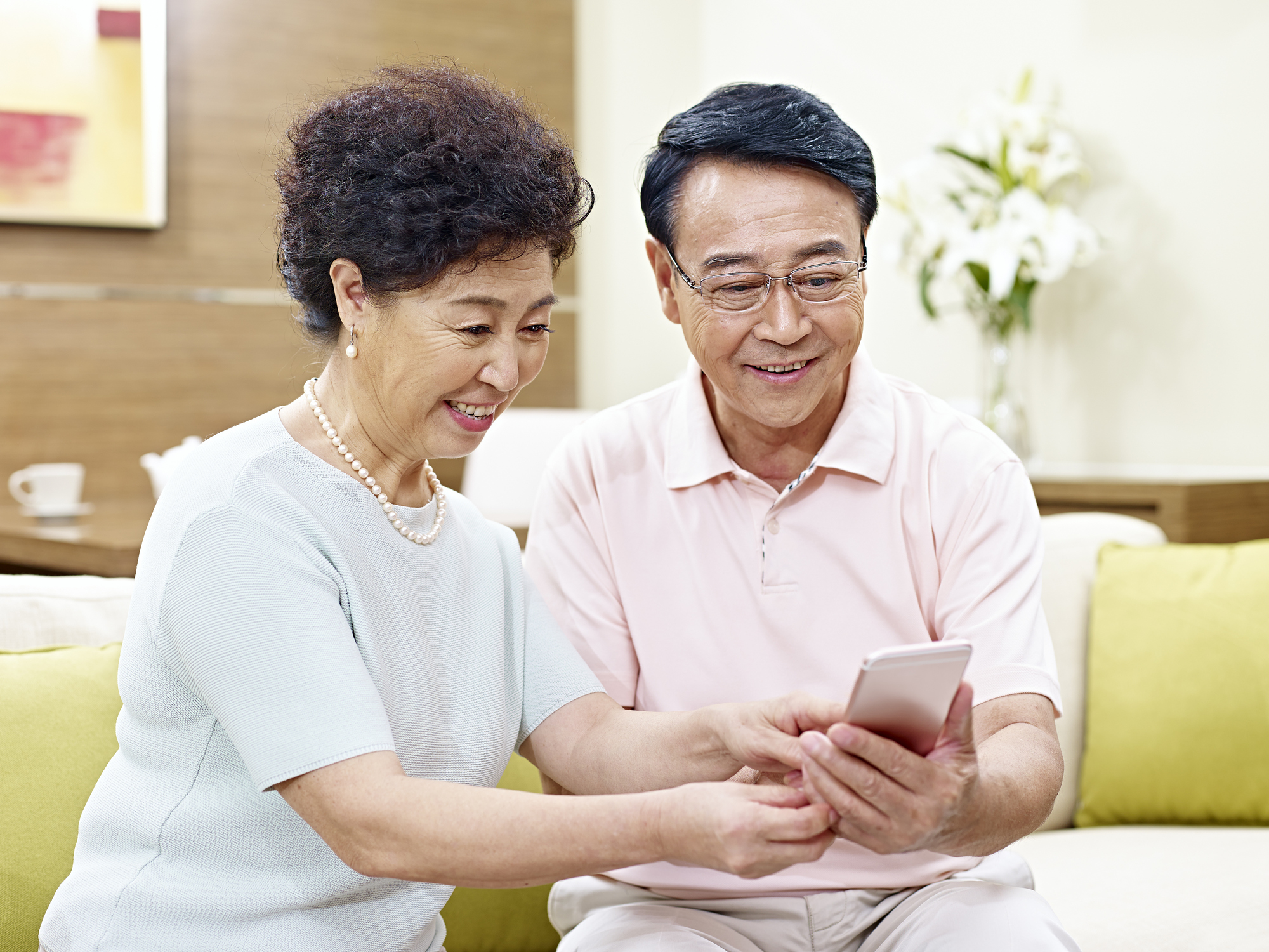 Two senior citizens look at a phone