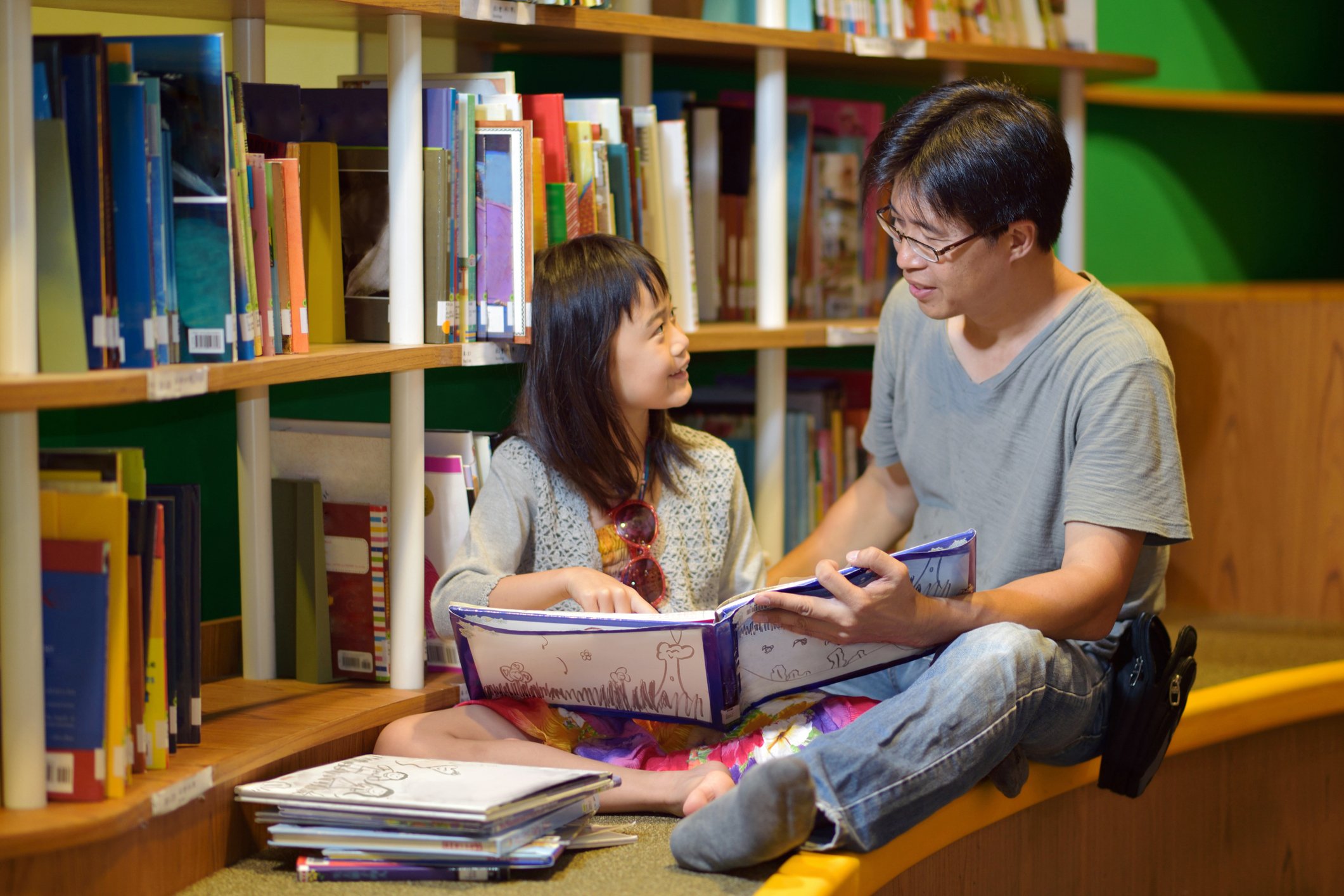 Father and daughter reading in the library