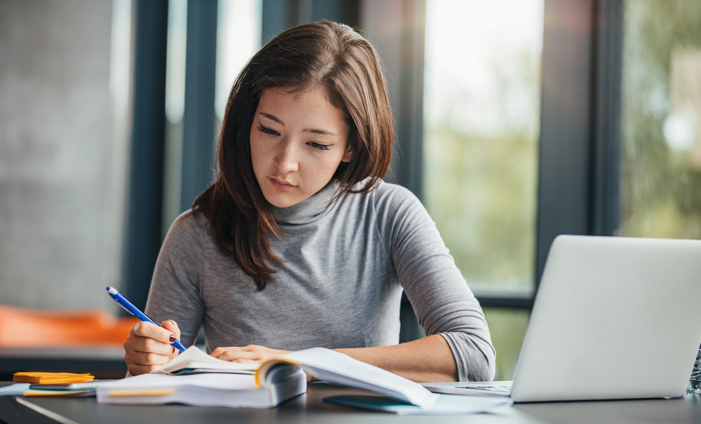 A woman writing down notes in her notebook.