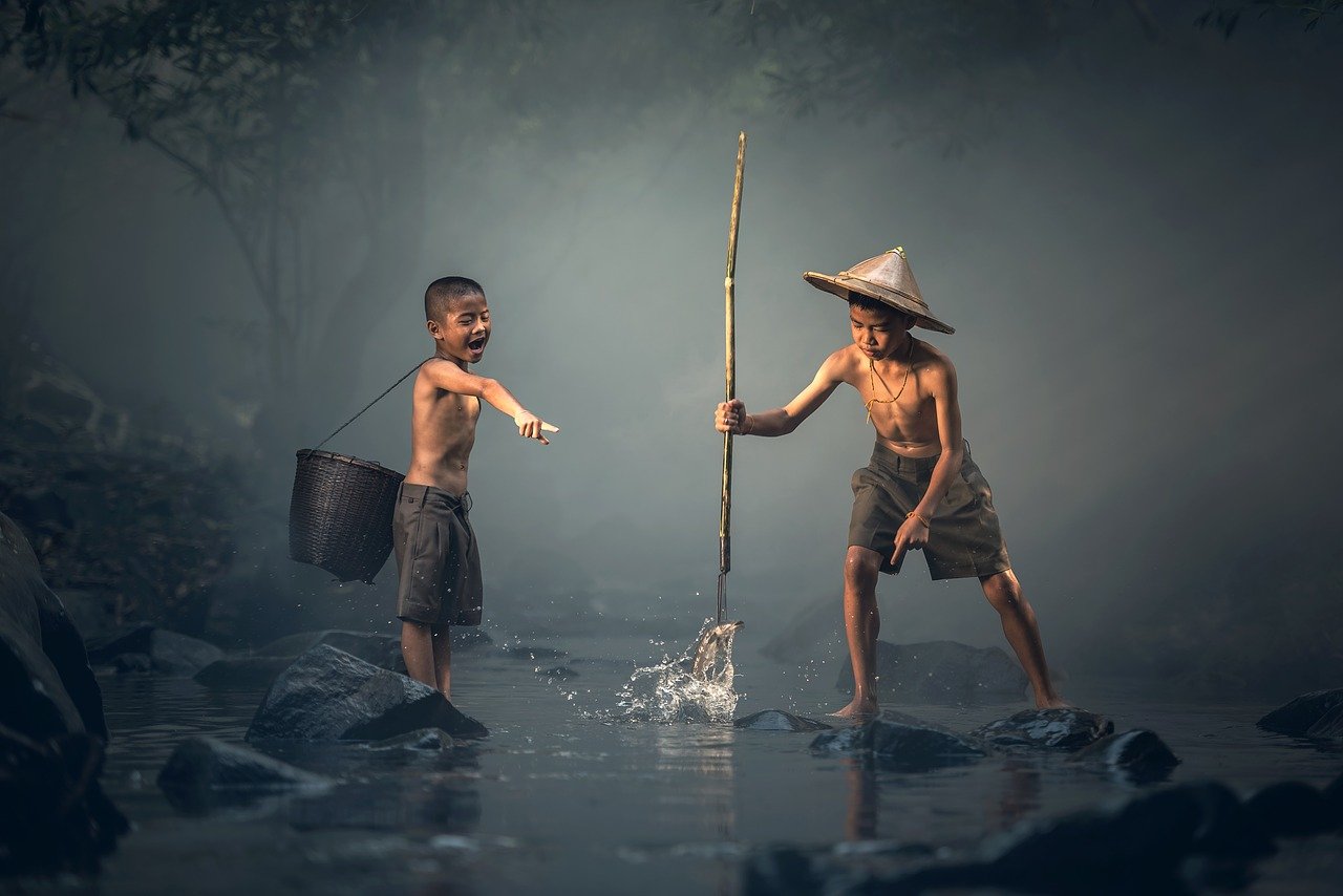 Two children spear fishing