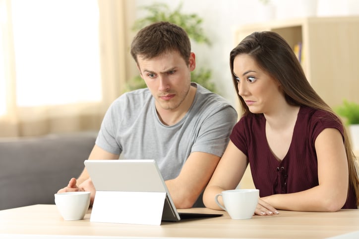 Confused couple studying about renting, sitting in a desk at home