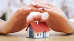 Hands covering a house