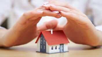 Hands covering a house