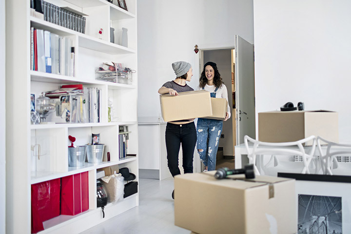 two women carrying boxes 