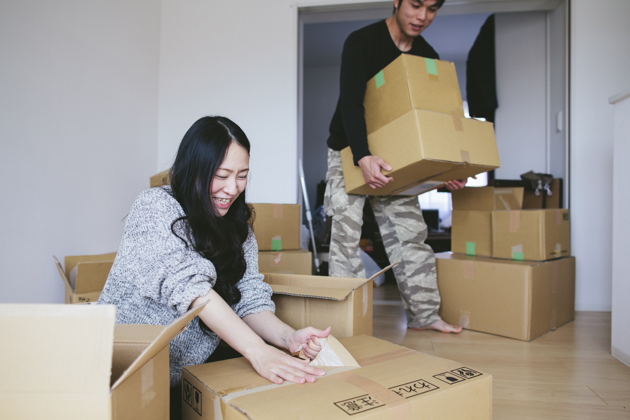 Two people unpacking boxes in a new house