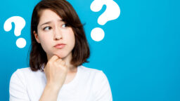 Woman between two big question marks