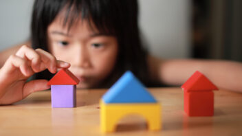 A child building houses with play blocks