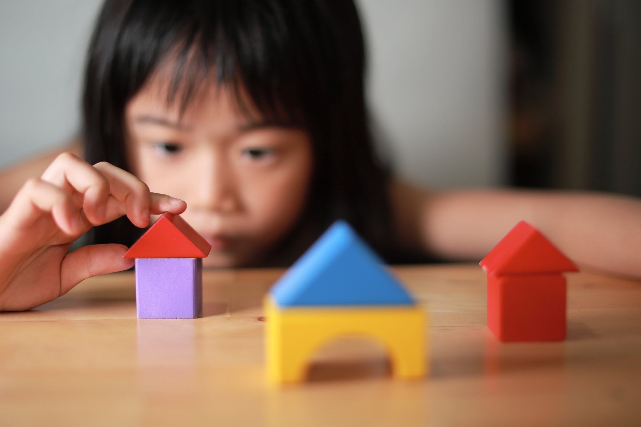 A child building houses with play blocks