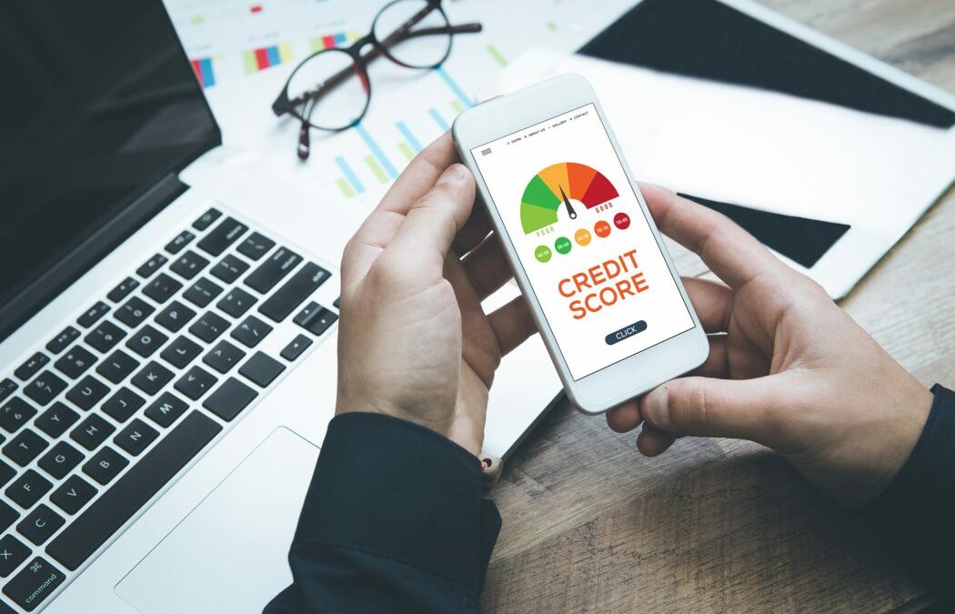 Person looking at his phone with an image of a credit score graph