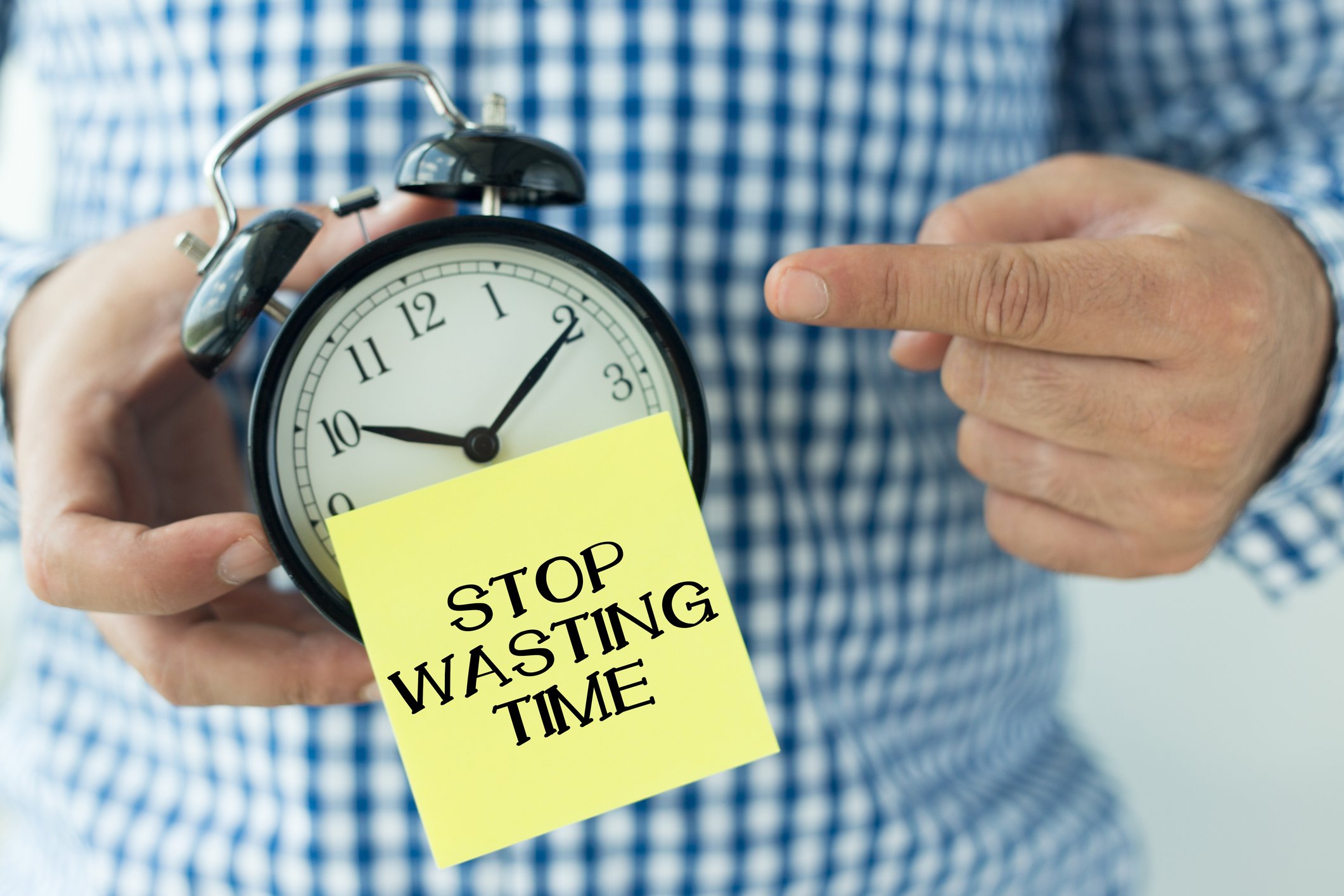Alarm Clock with sticky note saying "stop wasting time"
