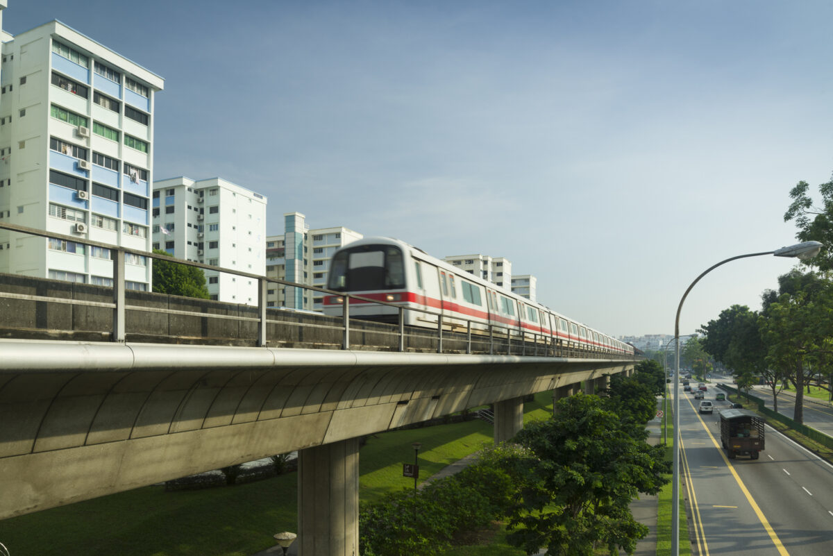 The MRT train on overpass tracks next to buildings in Yishun