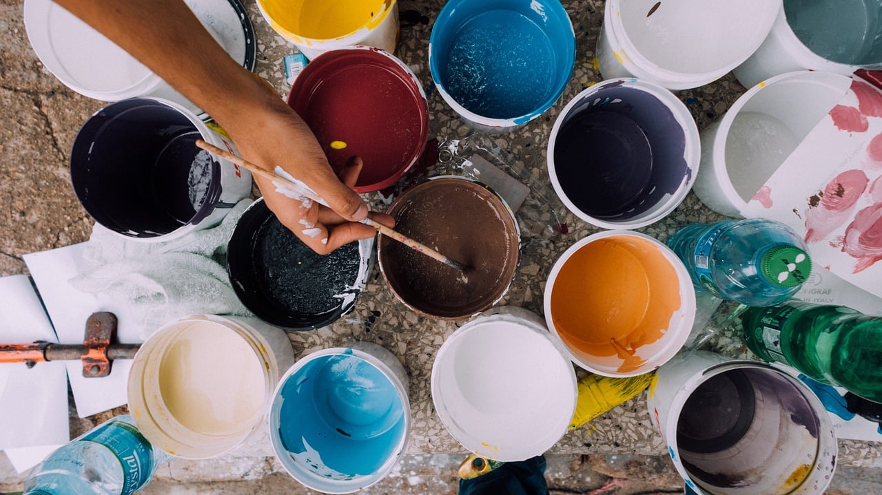Hand and brush over pots of paint