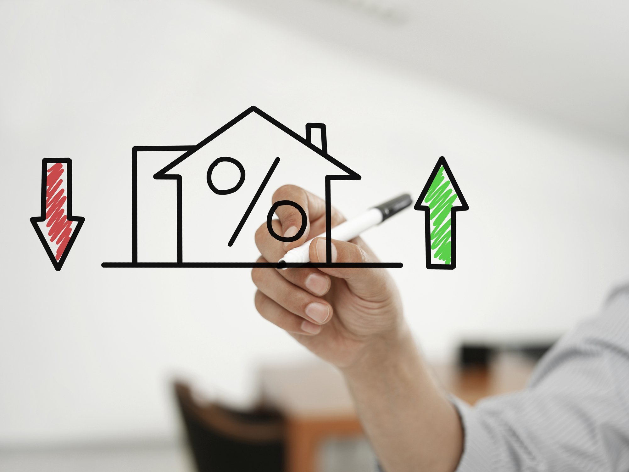 Businessman drawing "house and mortgage rates" on a virtual glass board