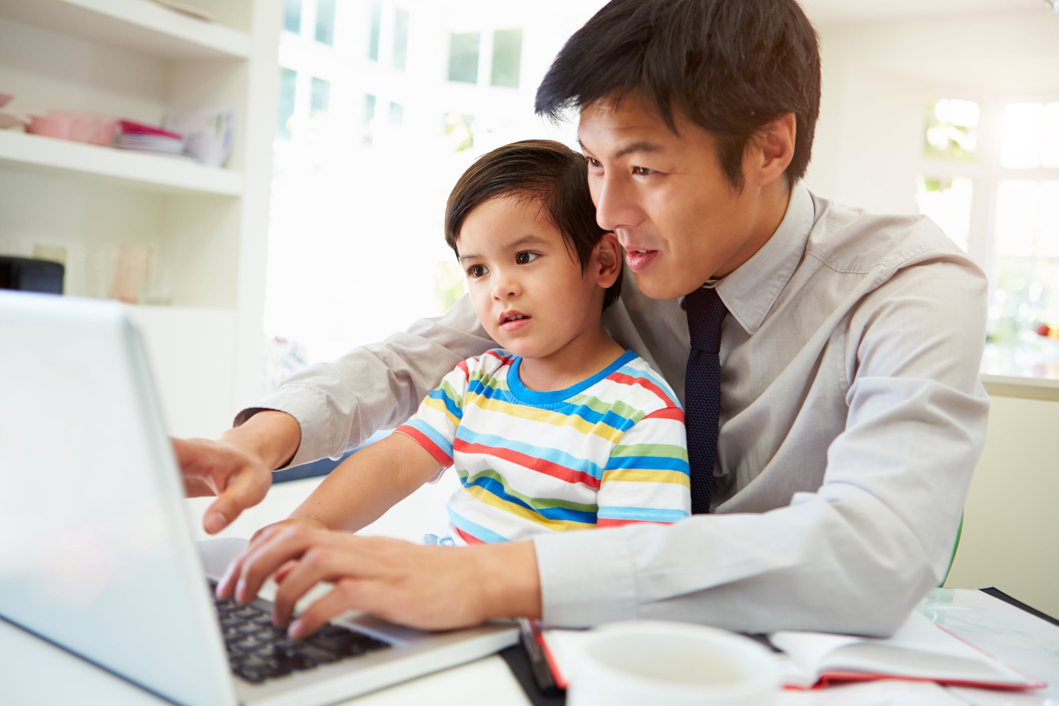 asian dad with kid on laptop