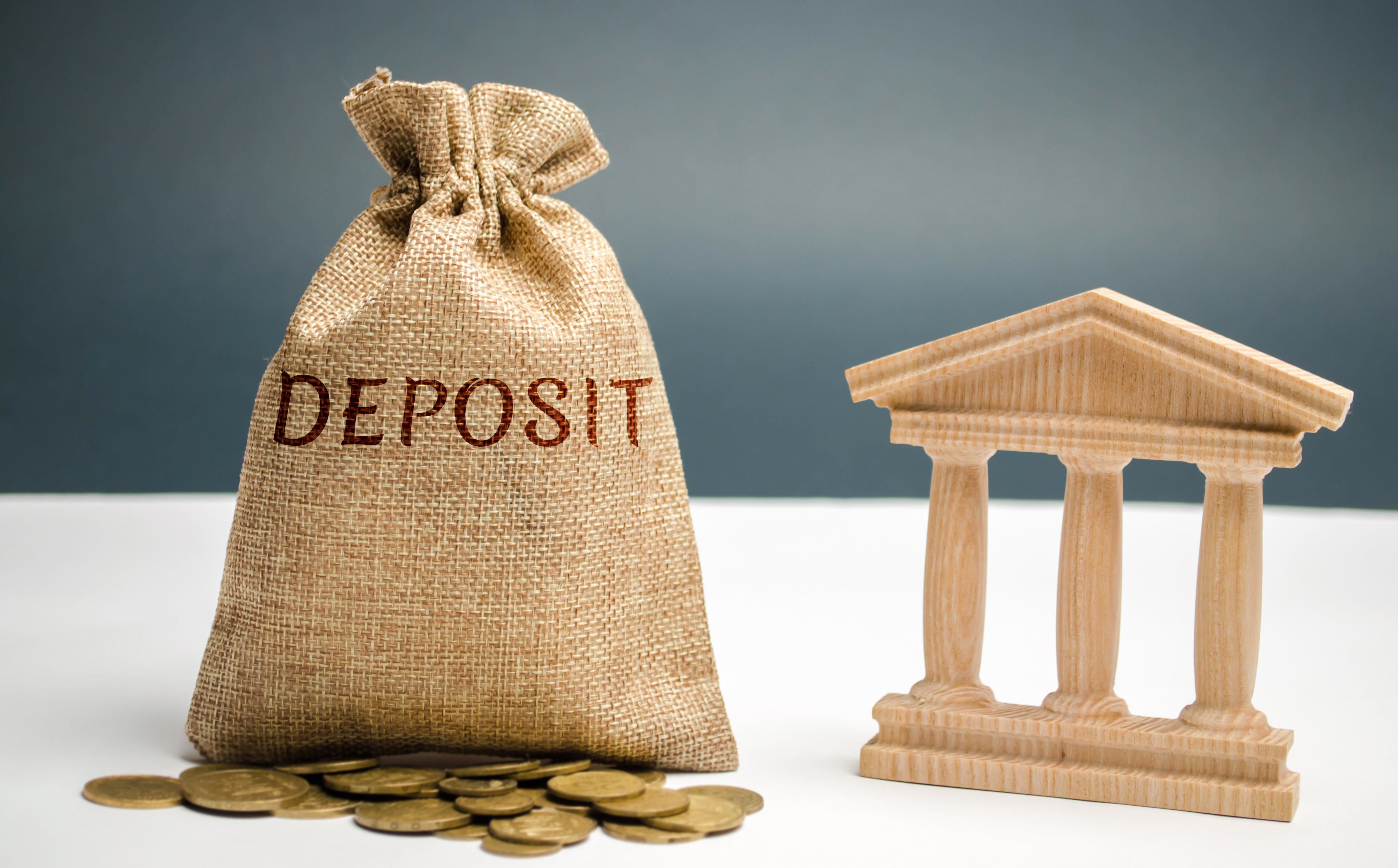 Moneybag that says "deposit" next to a house
