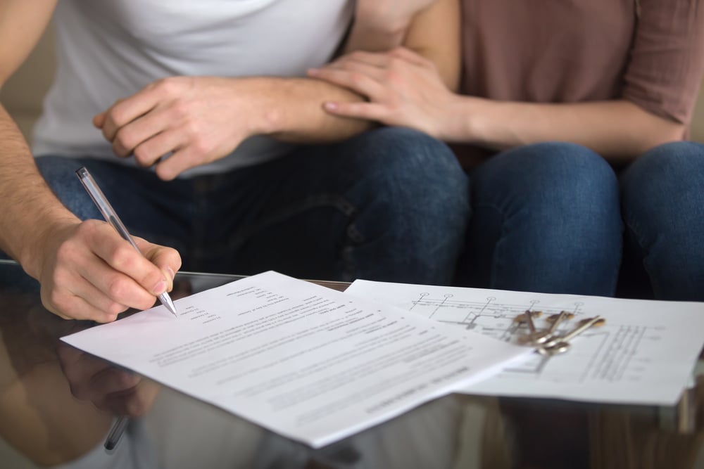 Two people about to sign a document.