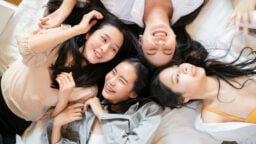 A group of girls lying on a jumbo bed.