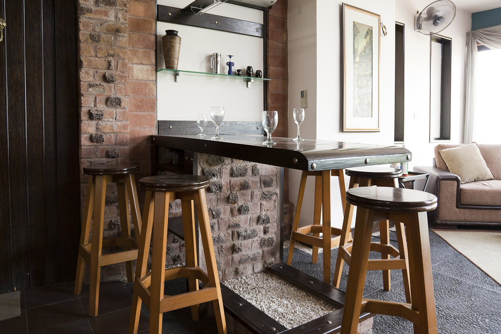 Kitchen counter with high chairs and glasses on top the table