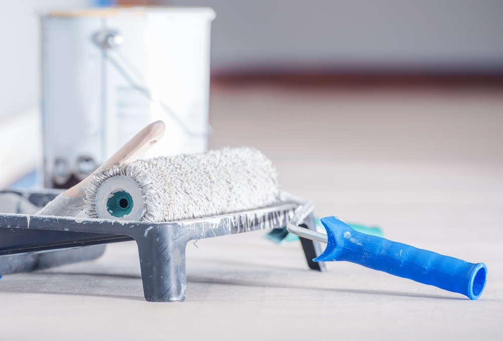 paint roller, tray and can of paint