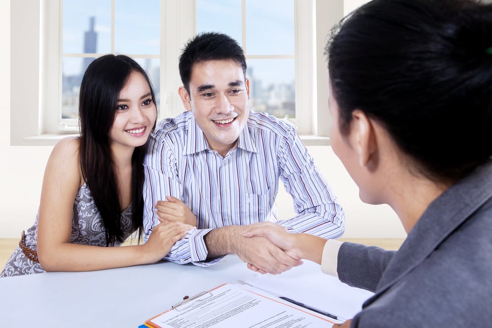 An asian couple signing up for home renovation loan.