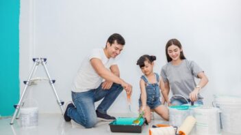 A family of three painting their living room.