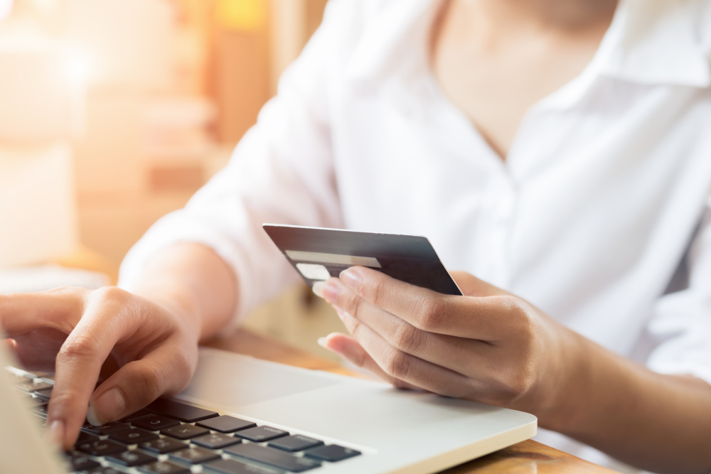 A woman purchasing things online with her credit card.