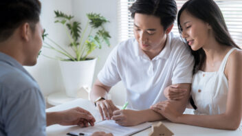 A couple signing an Option to Purchase to buy a home