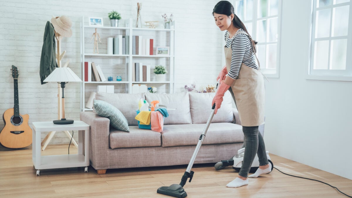 A woman vacuuming living room to allergy-proof home