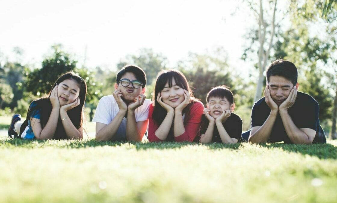 A family of five lying on grass