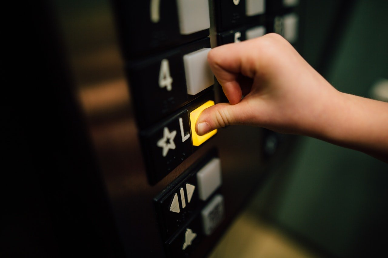 A person pressing a lift button.