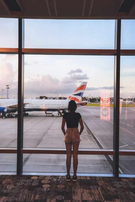 woman at airport lounge looking at airplanes