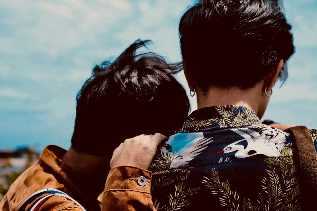 LGBTQ+ gay couple back facing