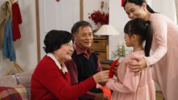 Senior elderly couple ang pow grandchildren Chinese New Year