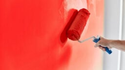 person painting wall red