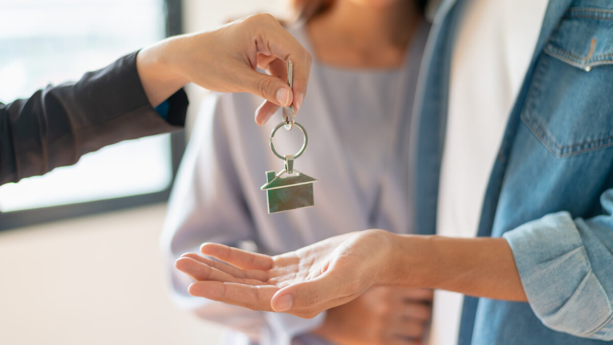 Buyers receiving house key from seller
