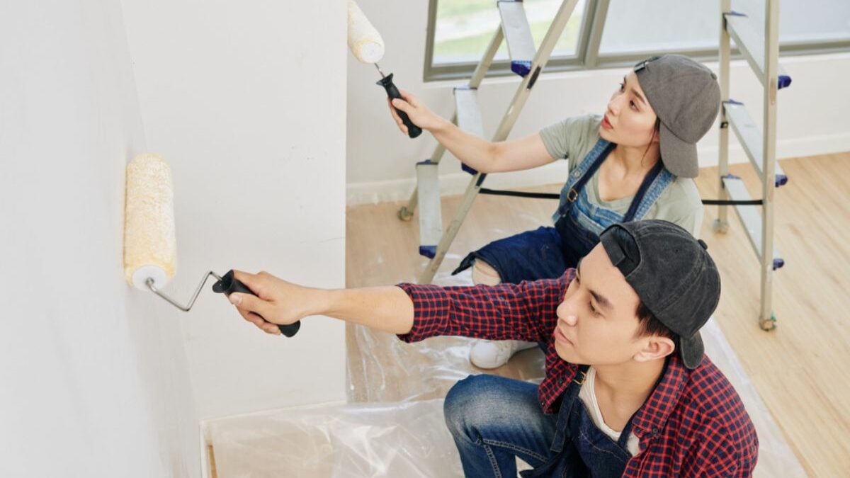 man and woman painting wall