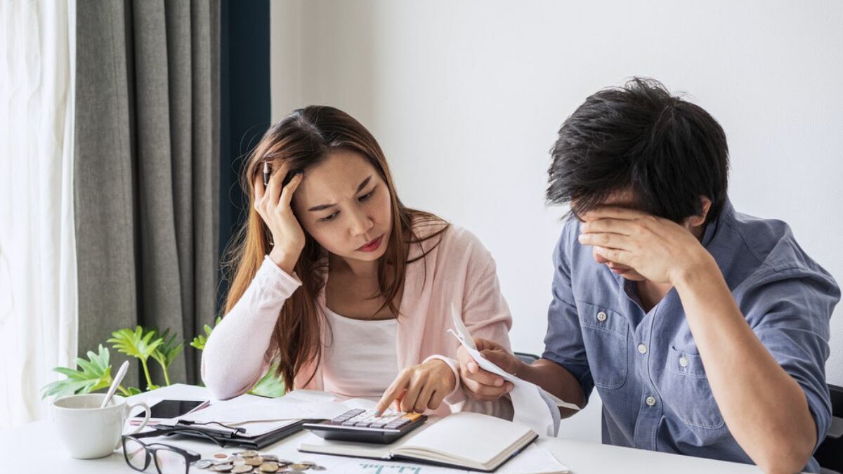 couple using calculator stressed