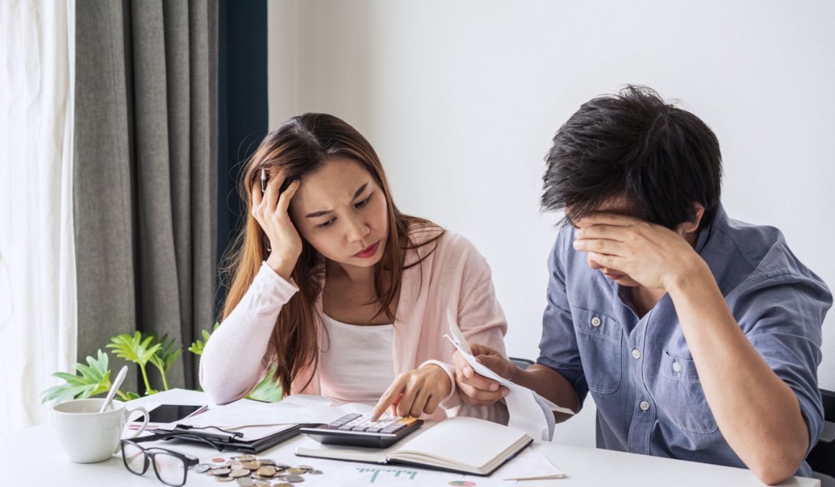 couple using calculator stressed