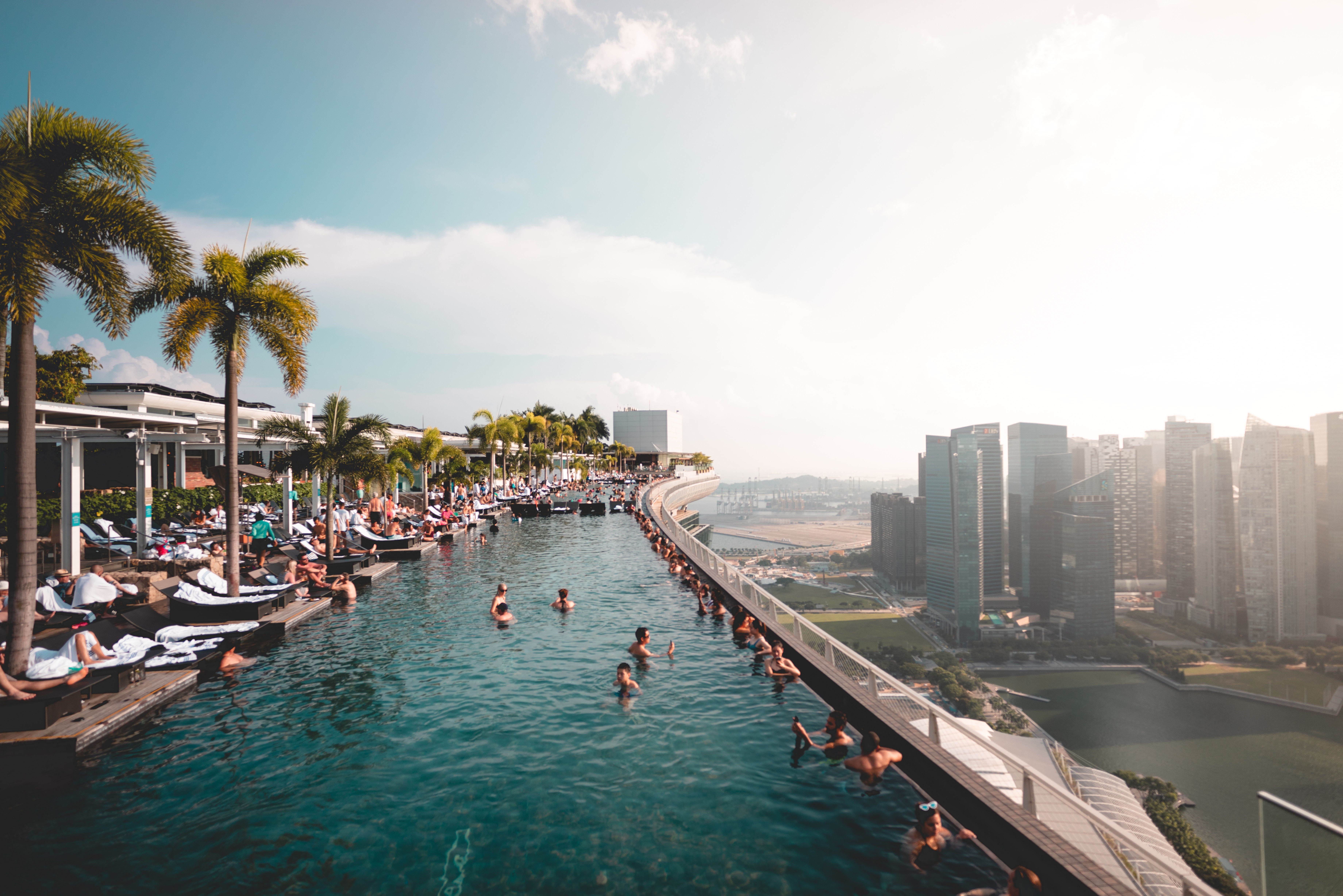 People swimming in Marina Bay Sands Infinity Pool overlooking Singapore's skyline. 