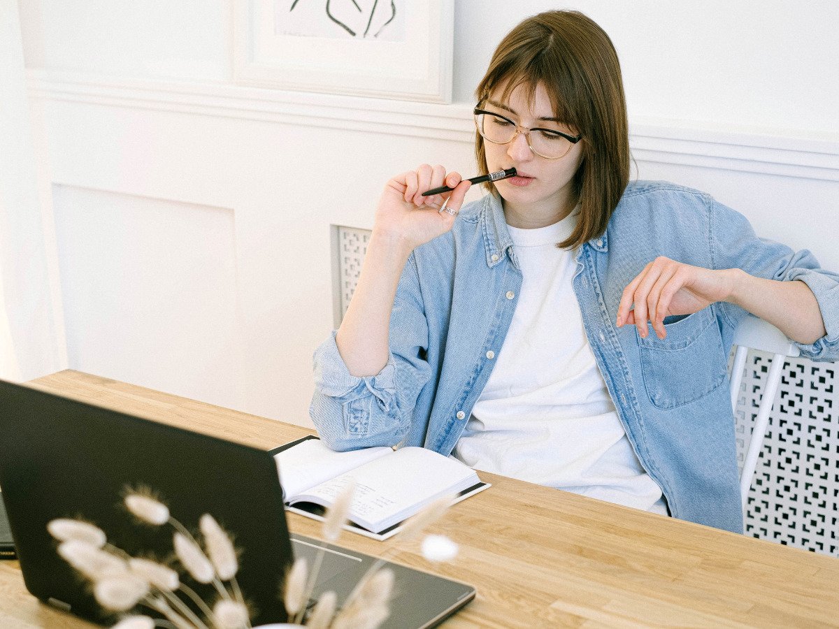 A girl in front of her laptop and a notebook