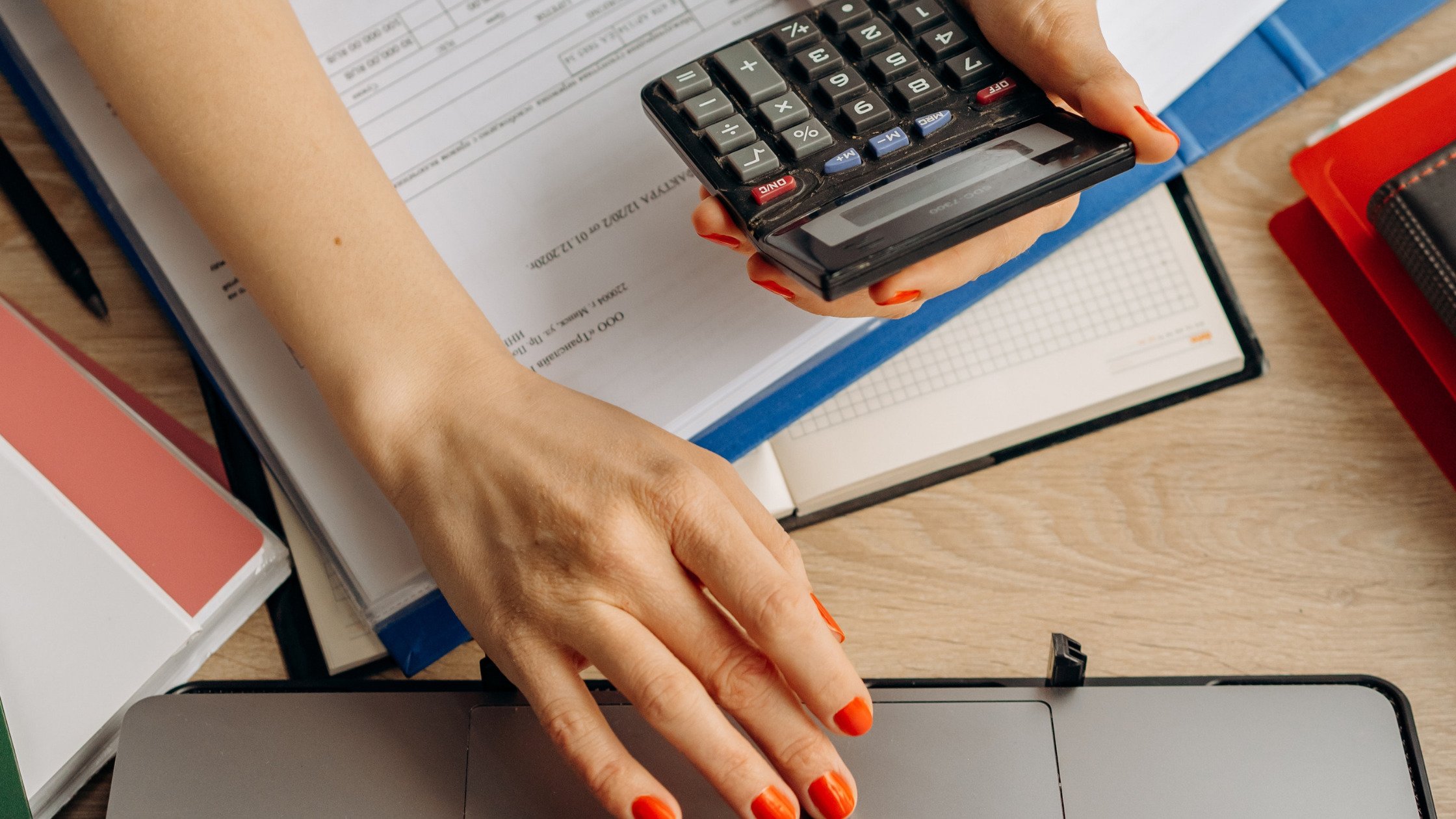 Person using calculator and laptop