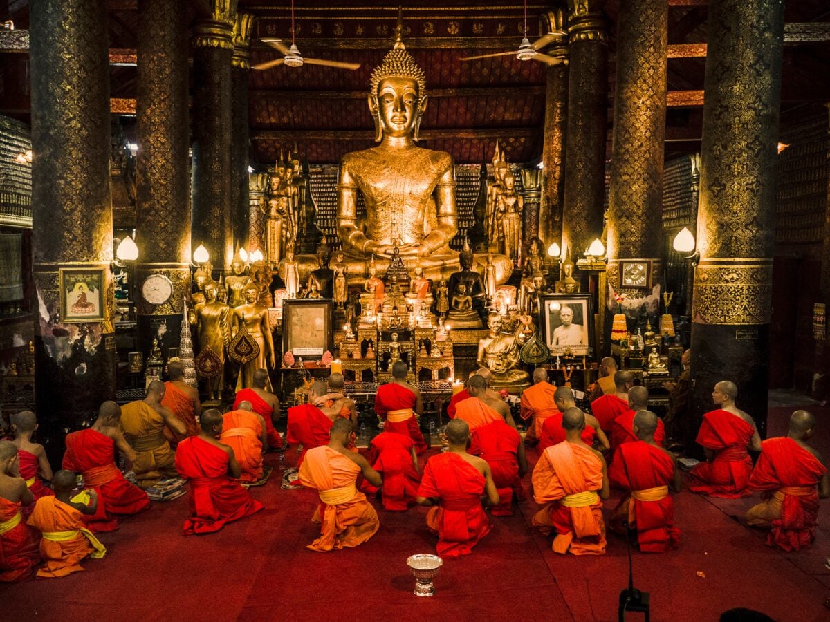 vesak day prayers with monks in front of buddha statue