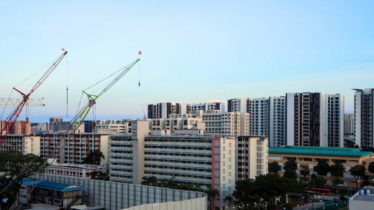 Construction site with two tall construction cranes building new housing development in Dakota, a residential neighbourhood in the east of Singapore