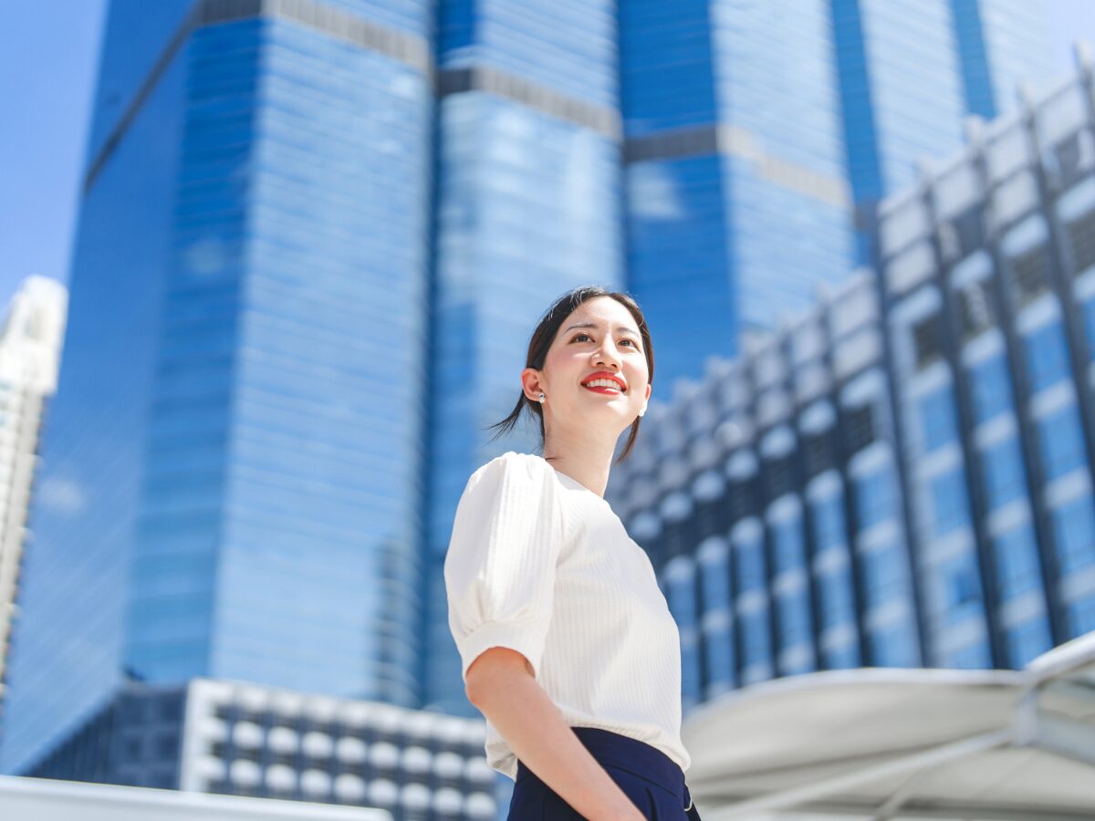 Portrait of successful business asian woman standing looking forward at outdoors in city