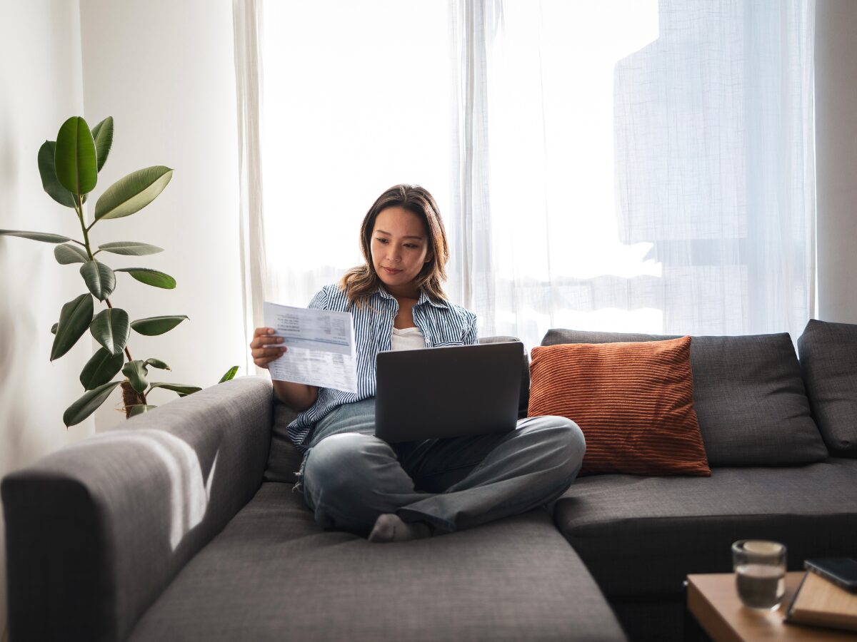 woman analysing documents while working on laptop