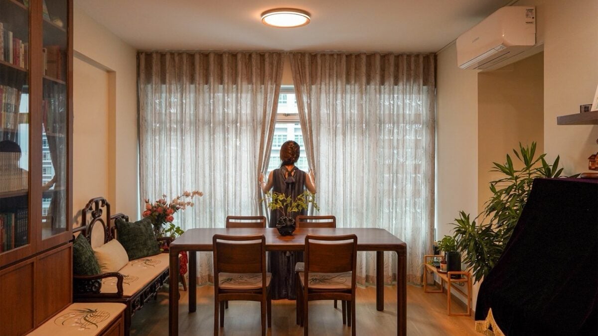 A woman looking out the window in her home renovated by an interior designer in Singapore